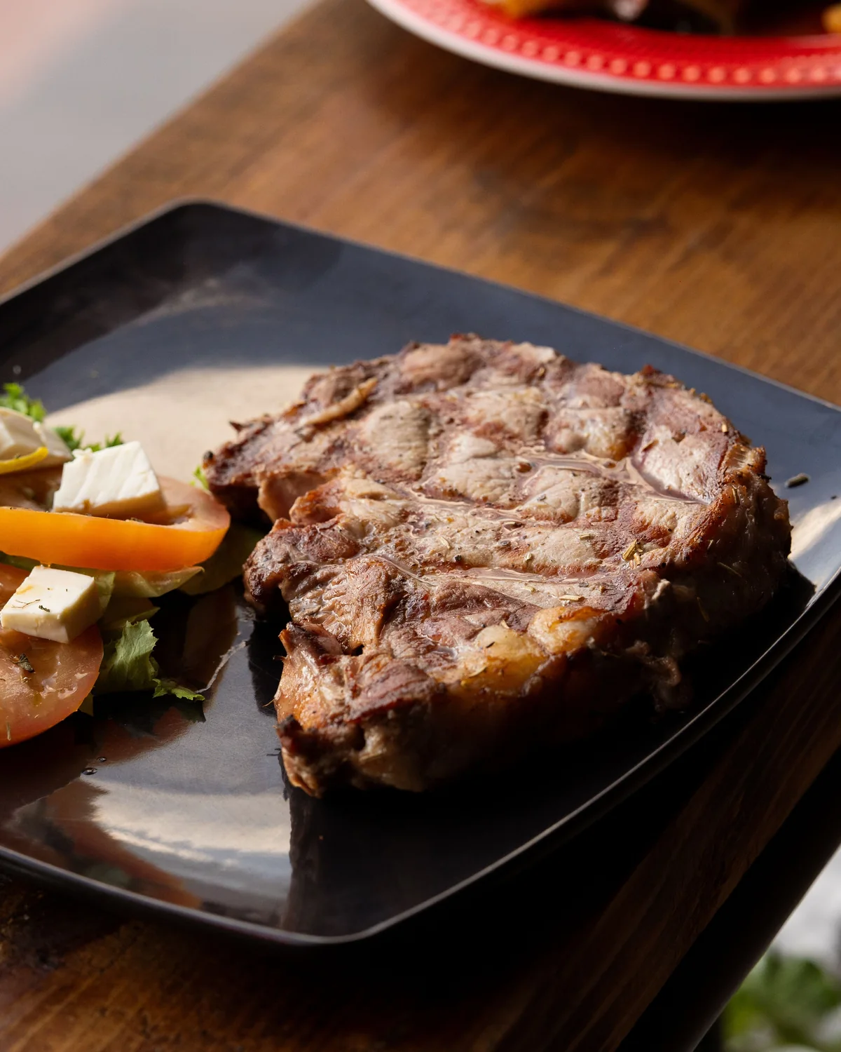 A grilled steak with salad and a glass of red wine on a wooden table (representative photograph of an Argentine dinner, not Señor Tango's own kitchen)